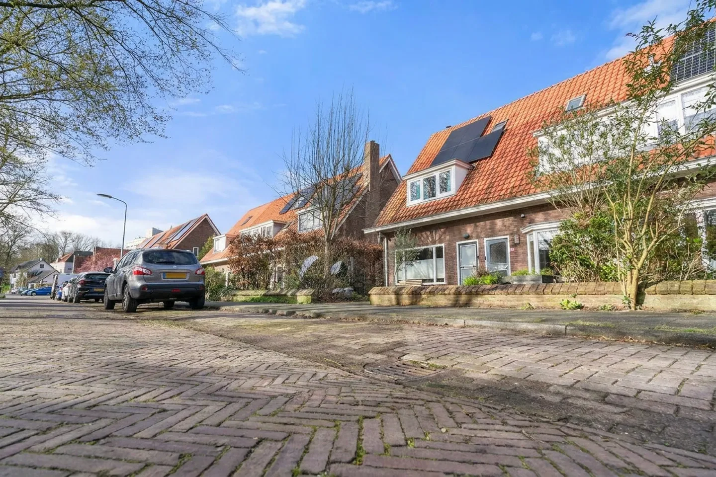 Makelaar Amersfoort – woningbezichtiging met Ditters Makelaars Jorik Otten, Makelaar van Ditters Amersfoort loopt naar de voordeur van de Ditters locatie in Amersfoort voor een bezichtiging, met aktetas en rode fiets bij de gevel.