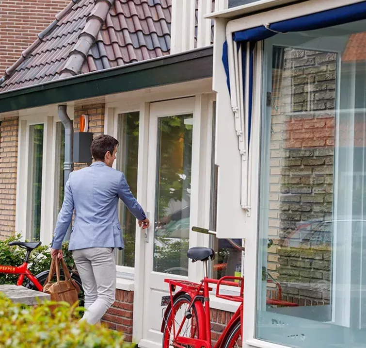 NVM makelaar, locatie Amersfoort loopt richting de de deur om open te doen.