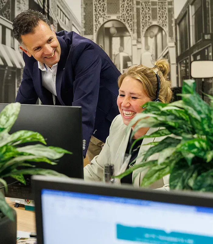 Makelaar in Ede die geconcentreerd achter zijn laptop werkt om de klant zo goed mogelijk van dienst te kunnen zijn.
