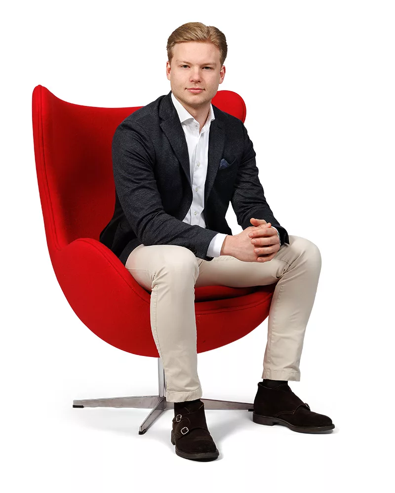 Portret van Jorick, makelaar bij Ditters Ede en Veenendaal, zittend in een rode stoel, professioneel en vriendelijk.