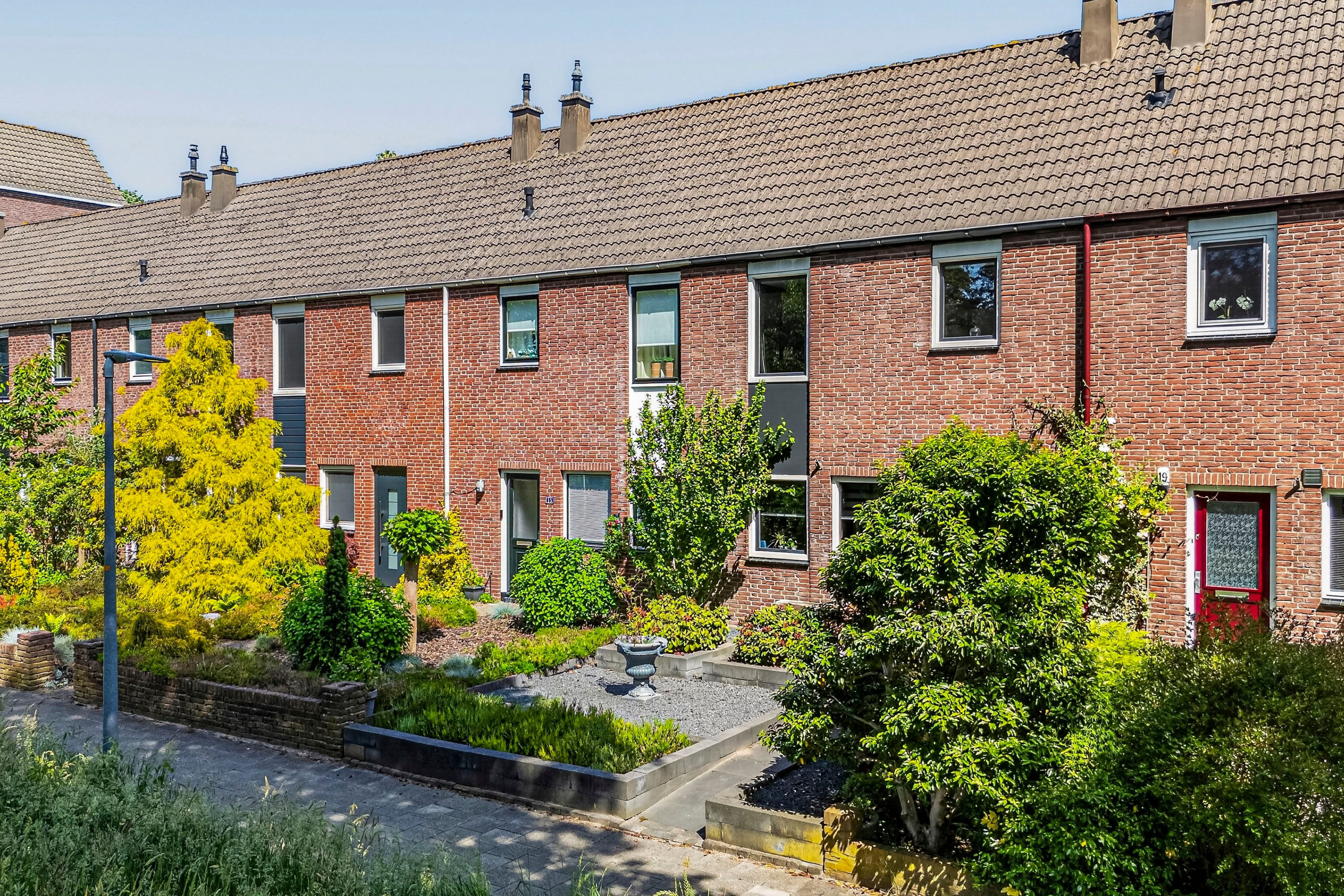 Makelaar Amersfoort – woningbezichtiging met Ditters Makelaars Jorik Otten, Makelaar van Ditters Amersfoort loopt naar de voordeur van de Ditters locatie in Amersfoort voor een bezichtiging, met aktetas en rode fiets bij de gevel.