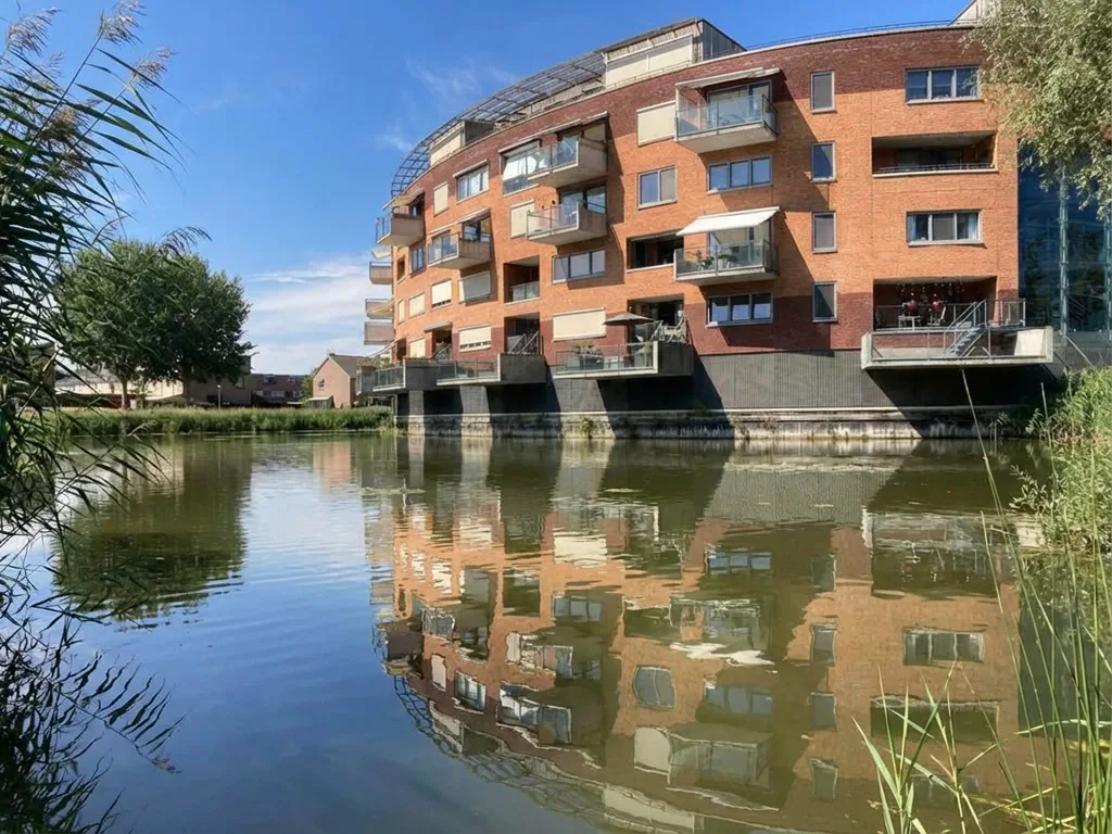 Appartementencomplex aan het water in de Arnhemse wijk Rijkerswoerd, met moderne balkons, baksteenarchitectuur en een rustige, waterrijke woonomgeving.