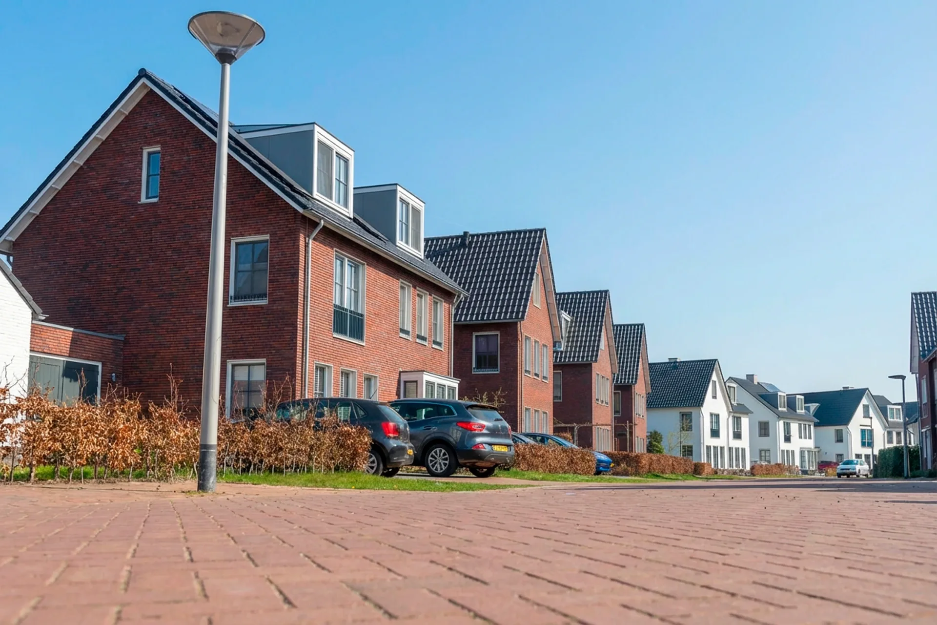 Jorik Otten, Makelaar van Ditters Amersfoort loopt naar de voordeur van de Ditters locatie in Amersfoort voor een bezichtiging, met aktetas en rode fiets bij de gevel.