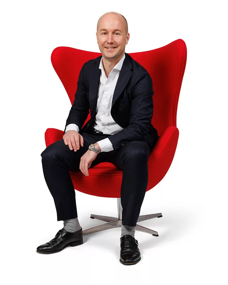 Jan Jurre van Ditters, ervaren nieuwbouwspecial, professioneel portret in rode stoel.