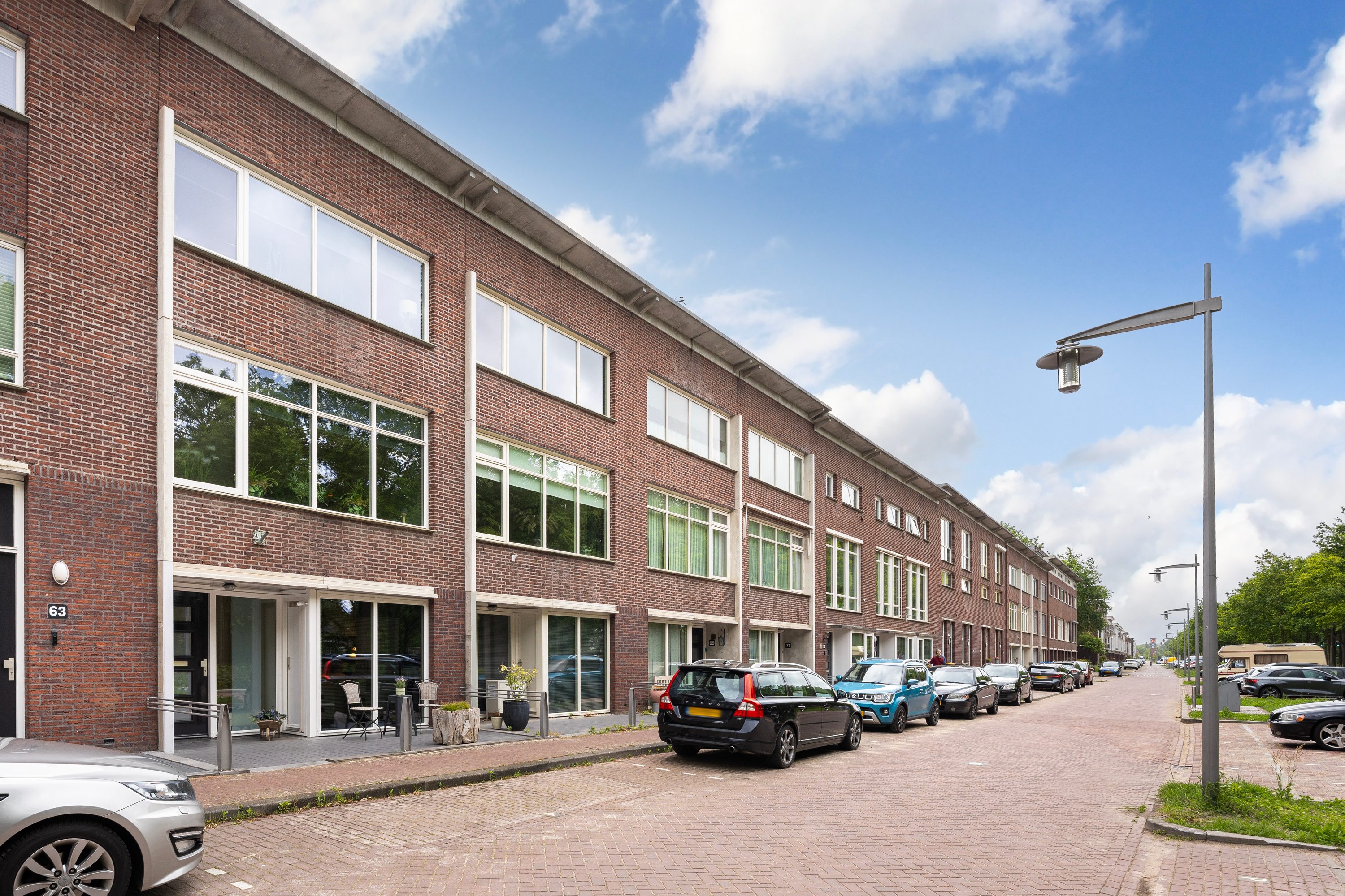 Makelaar Amersfoort – woningbezichtiging met Ditters Makelaars Jorik Otten, Makelaar van Ditters Amersfoort loopt naar de voordeur van de Ditters locatie in Amersfoort voor een bezichtiging, met aktetas en rode fiets bij de gevel.