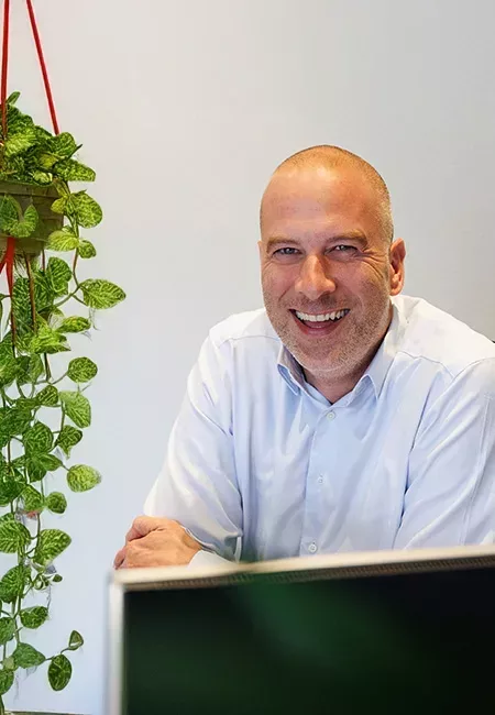 Makelaar van Ditters Arnhem achter bureau, vriendelijk contactmoment met klant, persoonlijk en laagdrempelig advies.