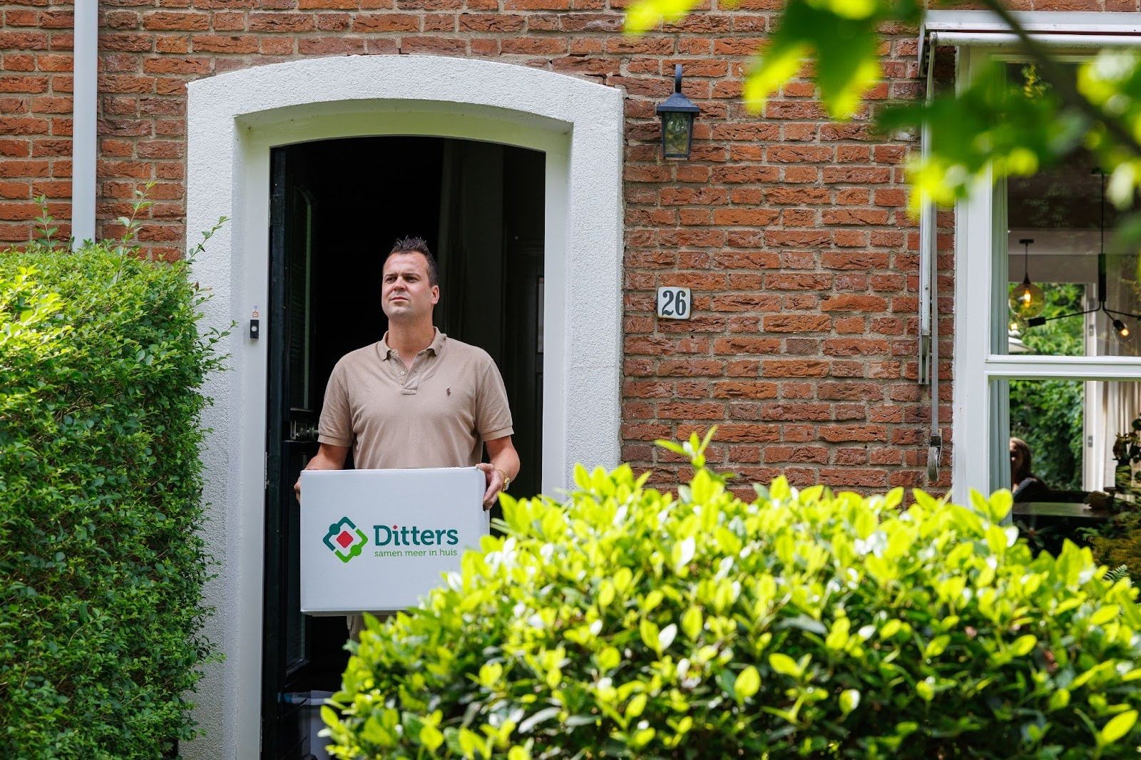 Jorik Otten, Makelaar van Ditters Amersfoort loopt naar de voordeur van de Ditters locatie in Amersfoort voor een bezichtiging, met aktetas en rode fiets bij de gevel.
