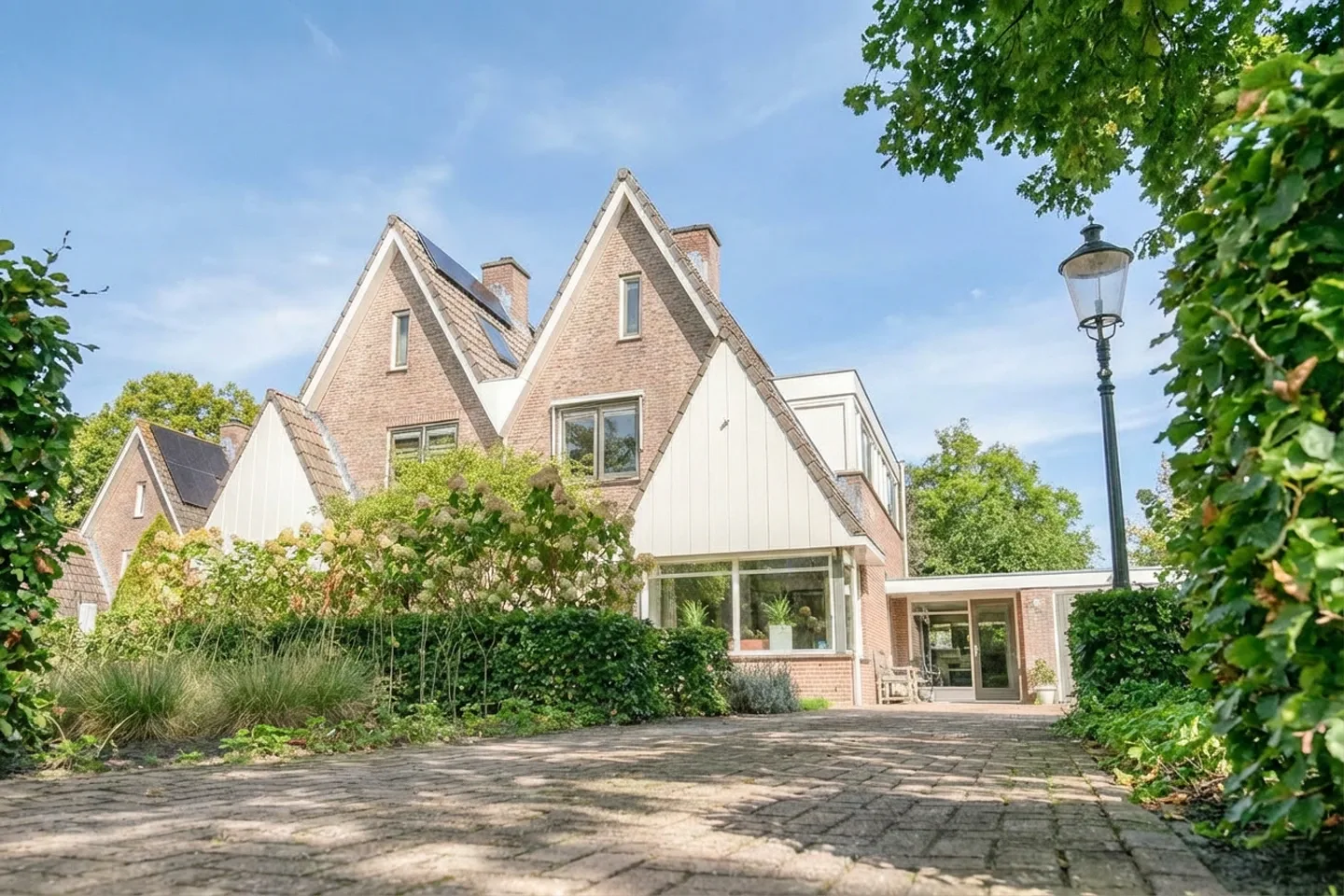 Vrijstaande woning in de groene buurt Petenbos in Veenendaal, omgeven door veel beplanting, een rustige straat en een ruim opgezette woonomgeving.